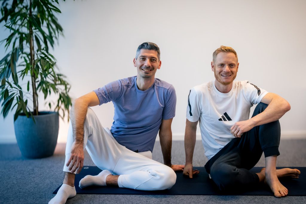 The Still and Strong Yoga Founders, Chris and Vlad on a Yoga mat.