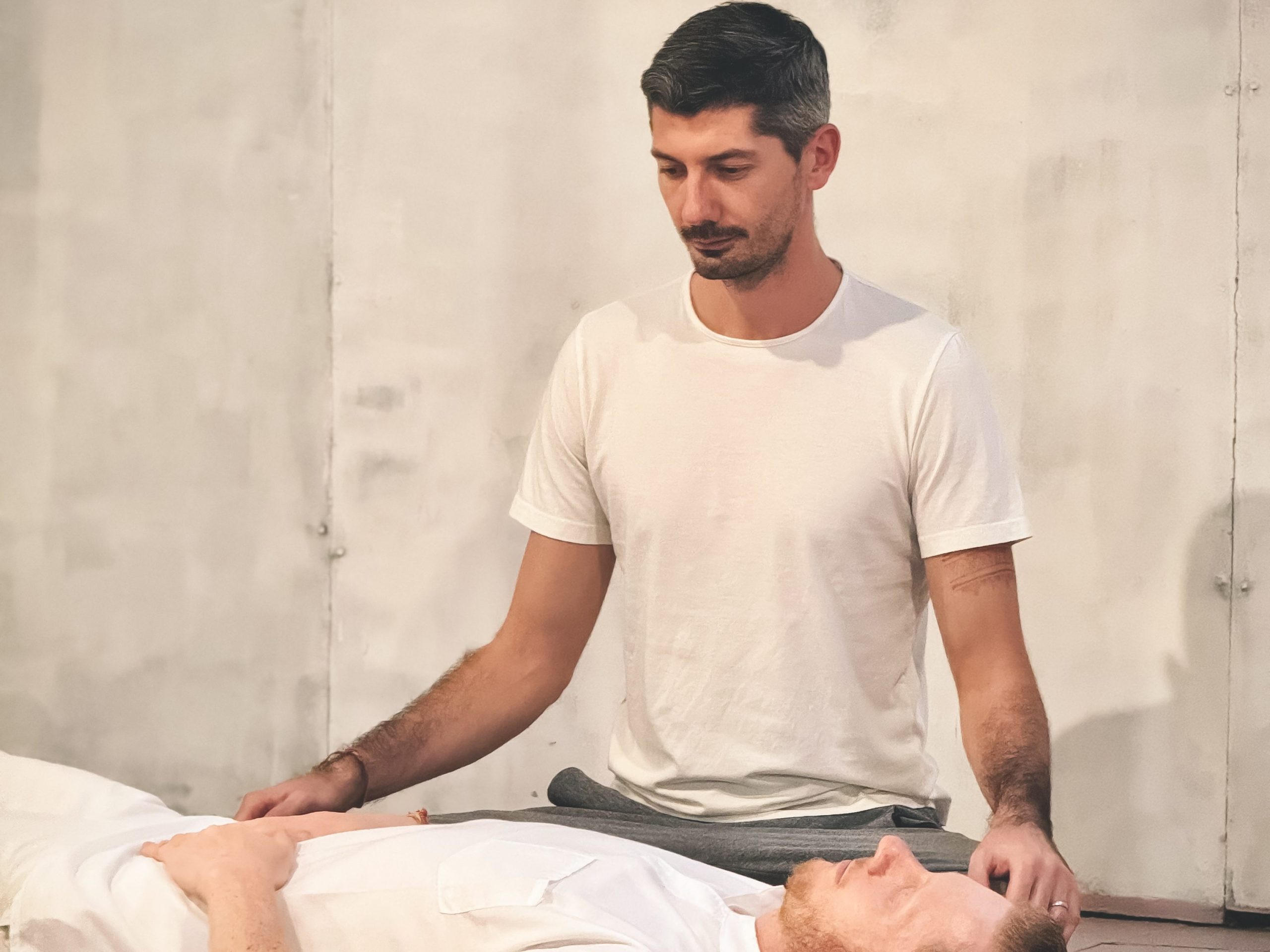 Vlad providing a Yoga Therapy session, doing a breath assessment on a client.